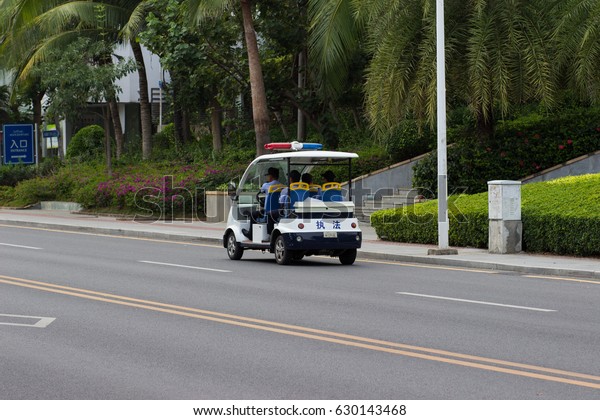 Sanya,\
China April 23, 2017 - An open electro car police service with\
officers inside patrols the roads of Hainan\
Island