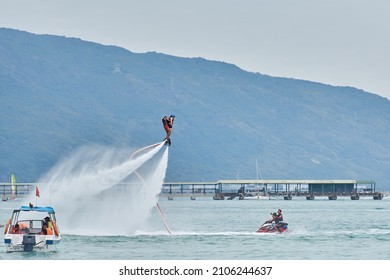 SANYA HAINAN, CHINA  - DECEMBER 19 2018: Flyboarding Tourists With A Water Jetpack On The City Beach 