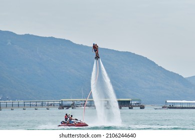 SANYA HAINAN, CHINA  - DECEMBER 19 2018: Flyboarding Tourists With A Water Jetpack On The City Beach 