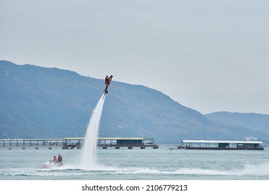 SANYA HAINAN, CHINA  - DECEMBER 19 2018: Flyboarding Tourists With A Water Jetpack On The City Beach 