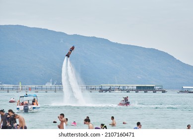 SANYA HAINAN, CHINA  - DECEMBER 19 2018: Flyboarding Tourists With A Water Jetpack On The City Beach 