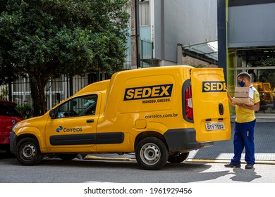 Sao Paulo, Brazil April, 24 - 2021:Logistic van from the Brazilian Post Office named Correios. Worker delivers sedex mail with anti covid mask.Government announces privatization of company