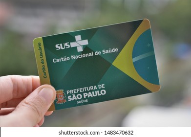 Sao Paulo / Brazil - August 20 2019: Closeup Of The Fingers Of A Caucasian Woman Holding A Cartão Nacional De Saúde (SUS - Sistema Único De Saúde), Brazilian Public Health Care System Card.