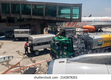 Sao Paulo, Brazil, February 25, 2022. Petrobras Aviation Tanker Truck With Fuel And Workers Loading Luggage In The Aircraft Yard At Congonhas Airport In São Paulo