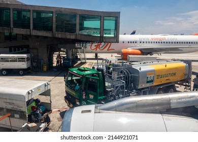 Sao Paulo, Brazil, February 25, 2022. Petrobras Aviation Tanker Truck With Fuel And Workers Loading Luggage In The Aircraft Yard At Congonhas Airport In São Paulo