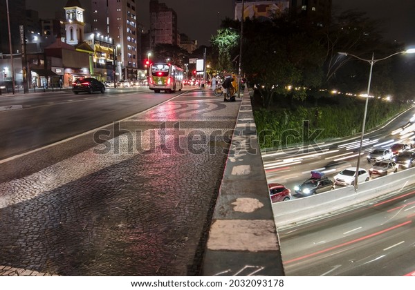 Sao Paulo, Brazil, July 27\
, 2021. Night time lapse of vehicles and pedestrians traveling\
along the Santa Generosa Viaduct and heavy traffic on 23 de Maio\
Avenue.