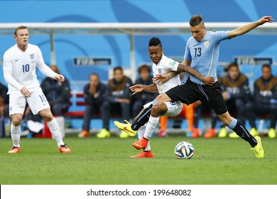 SAO PAULO, BRAZIL - June 19, 2014: Jose Gimenez of Uruguay and Raheem Sterling of England compete for the ball during the game between Uruguay and England at Arena Corinthians. No Use in Brazil.