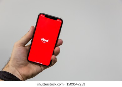 Sao Paulo, Brazil; September 12, 2019: Man holding a Smartphone with ifood logo on it. ifood is a Brazilian company in the segment of food delivery, Brasilian Fintech.