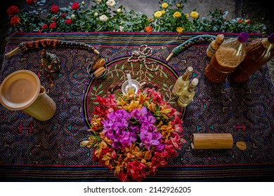 Sao Paulo, SP, Brazil - April 26 2022: Altar for ceremony with colorful flowers, shipibo fabric, kuripes for snuff application and bottles with Ayawasca