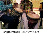 Sao Paulo, SP, Brazil - November 11 2021: Men, with traditional indigenous clothes and handicrafts playing djembe