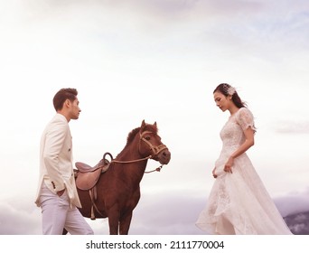 Sapa city, Vietnam - February 2021: The bride and groom take a wedding photo with a powerful horse. Beautiful wedding photo of a happy couple