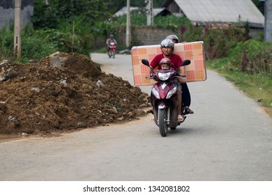 Sapa, Lao Cai, Vietnam - 08 16 2014: Man With Family Carrying A Mattress On A Motorbike In SaPa. Vietnamese People Are Used To Load And Transport A Lot Of Things On Motorcycle. Vietnam