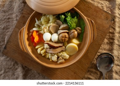 Sapo Tahu. Chinese Indonesian Tofu Dish, Served In Claypot. The Picture Is On Grainy Textured. With Webbed Wooden Plate Mat. Selective Focus.