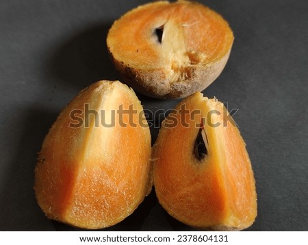 sapodilla fruit slices on a black background