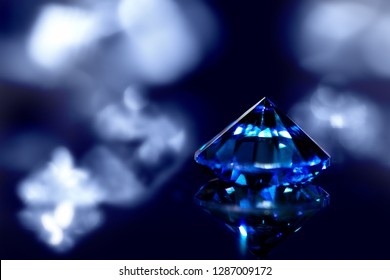 Sapphire or blue diamond with brilliant-cut and shiny background, closeup