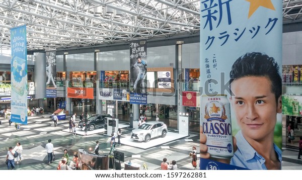 Sapporo,\
Hokkaido, Japan - Aug 13 2015: Domestic terminal atrium of New\
Chitose Airport. Advertising hanging banners about Sapporo Beer and\
Nippon-Ham Fighters professional baseball\
team.