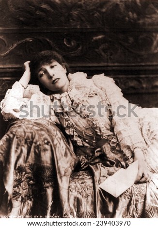 Sarah Bernhardt (1844-1923), French actress, reclining on a divan in an 1880's portrait.