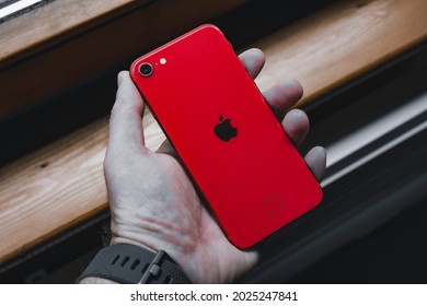 Sarajevo, Bosnia And Herzegovina - 06 09 2021: Male Hand Holding IPhone SE 2020 In Product Red Color Variant, Back Side Facing Up.