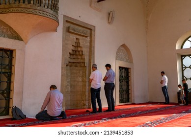 SARAJEVO, BOSNIA AND HERZEGOVINA - July 21, 2021: View From The Gazi Husrev-beg Mosque, A Major Islamic Building Built In The 16th Century, Showing People Praying Outside At The Portico.