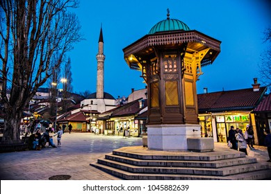 SARAJEVO, BOSNIA AND HERZEGOVINA - March 2018: Sebilj fountain in Pigeon Square, Bascarsija quarter by evening in lights, Sarajevo, Bosnia and Herzegovina