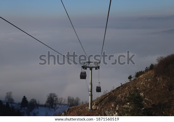 Sarajevo cable car\
above smog in wintertime\
