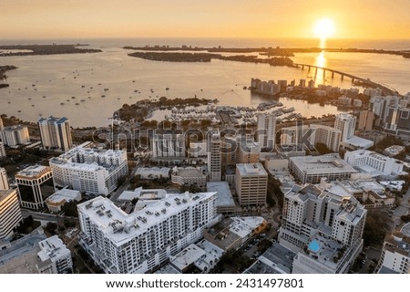 Sarasota Bay marina with luxury yachts and Florida city architecture at sunset. High-rise office buildings in downtown district. Real estate development in Florida. USA travel destination