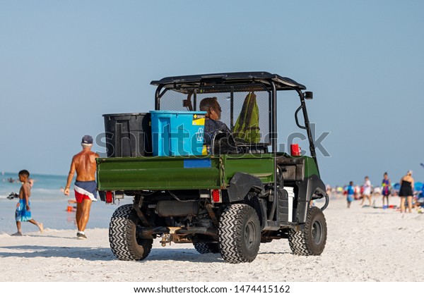 Sarasota, Florida,\
USA - May 26, 2019: The car for garbage collection from the beach.\
Cleaning on the beach, clean beach. Background ocean and white\
sand. Copy space. Soft\
focus.