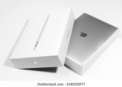 Saratov, Russia - February 26, 2022: unboxing new modern Macbook Air 13 inch with M1 processor from stylish packaging topview, white background. Advertising of modern technology and portable device.