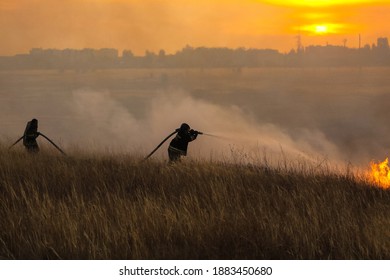 Saratov, Russia - October 10, 2020: Firemen Fighting Wild Fire In Field, Sunset