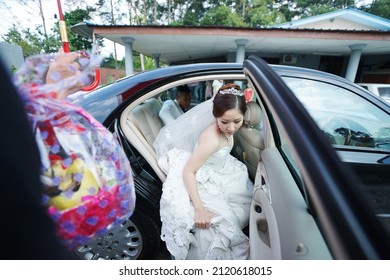 Sarawak, Malaysia – August 1, 2013: Portrait Of A Young Pretty Asian Woman Bride In White Lace Wedding Dress Carefully Existing From The Black Car.