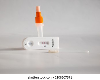 SARS-CoV-2 Antigen Rapid Test (Nasal Swab) For Self Testing With Used Sterile Swab And Test Cassette With Positive Result Isolated On White In Bright Sunlight. COVID-19 Ag.