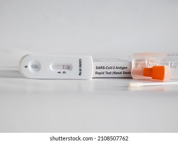 SARS-CoV-2 Antigen Rapid Test (Nasal Swab) For Self Testing With Used Sterile Swab And Test Cassette With Negative Result Isolated On White In Bright Sunlight. COVID-19 Ag.