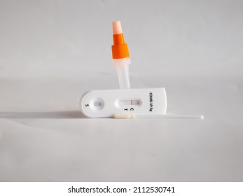 SARS-CoV-2 Antigen Rapid Test (Nasal Swab) For Self Testing With Used Sterile Swab And Test Cassette With Negative Result Isolated On White In Bright Sunlight. COVID-19 Ag.