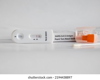 SARS-CoV-2 Antigen Rapid Test (Nasal Swab) For Self Testing With Used Sterile Swab And Test Cassette With Negative Result Isolated On White In Bright Sunlight. COVID-19 Ag.