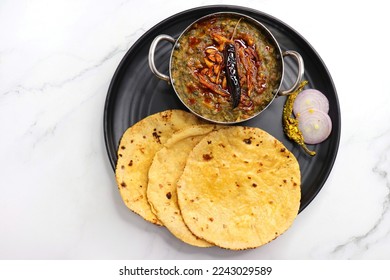 Sarson ka saag and Makke di roti. mustard leaves curry. It's a popular Punjabi winter dish made using corn meal and mustard leaves. served with onions and green chili. with copy space.
