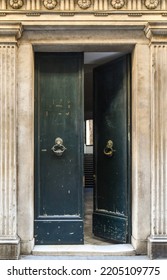 Sarzana, La Spezia, Liguria, Italy - 07 05 2022: Close-up Of The Open Entrance Door Of An Old Palace With Metal Knockers And Stone Frame	