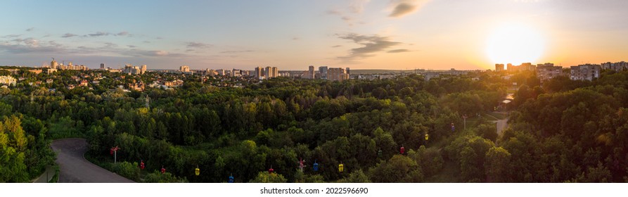 Sarzhyn Yar with cable car attraction aerial view in green summer Kharkiv city popular recreation Central Park. Recreation area in city center in sunset wide panorama