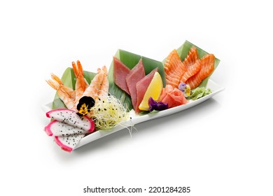 Sashimi sushi set with raw fish, on banana leaves, on a white plate, isolated on white background. Packshot for restaurant menu.