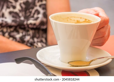 sat at a restaurant table with an empty cup of coffee