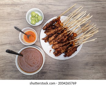 Sate Ayam (Chicken satay) served with peanut sauce, chili sauce and lime. One of the popular Indonesian cuisine.