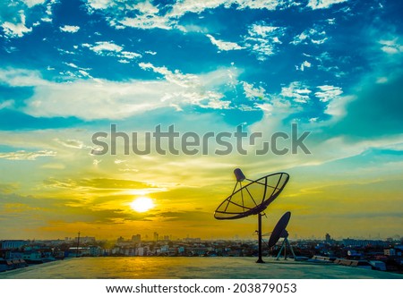 satelite dishes with sunset and city background