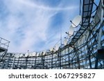 Satellite antennas are on the roof of the building. TV station with a lot of receiving devices. Telecommunication equipment of the telecentre