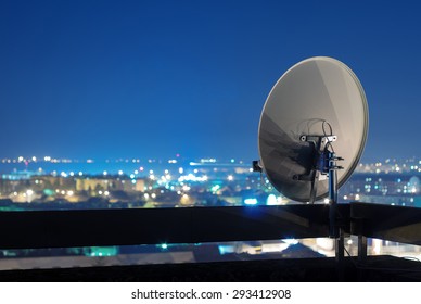 Спутниковая антенна на на верхней части здания в городской зоне ночью.