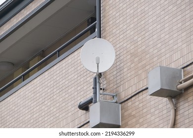 Satellite Dish and Antenna TV hanging on the outer wall of mansion