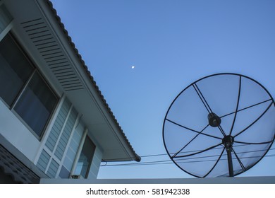 Satellite dish on the roof,blue sky with part of the moon