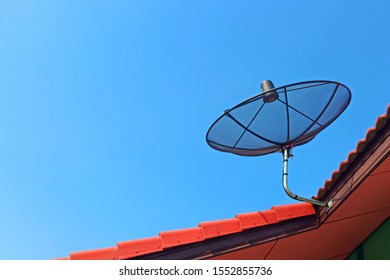 Satellite Dish For Watching Satellite TV Programs Installed On The Roof With A Backdrop Of Bright Blue Skies.