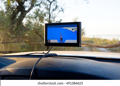 Satellite navigation system in car. GPS device in a car. Outdoor, adventures and travel destination. Monitor display with touch screen showing the end of path, road in countryside with forest.