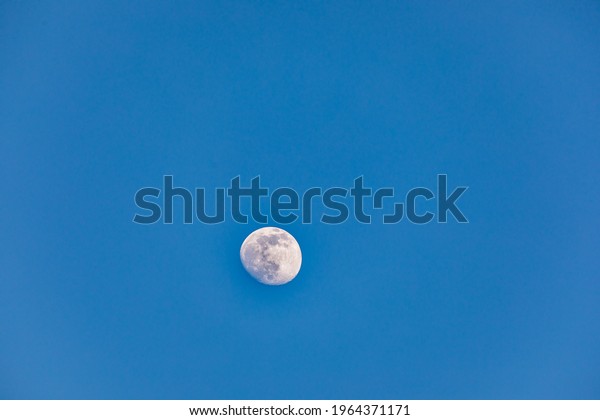 Satellite\
of planet Earth.  Moon in a clear sky. \
Dusk.