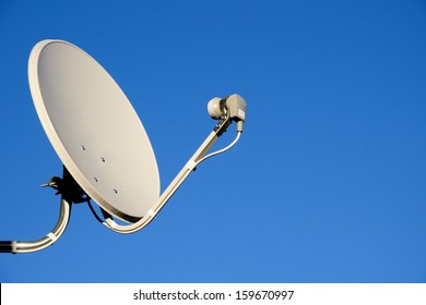 Satellite TV antenna on blue sky background