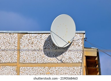 Satellite TV Antenna On The Wall Of The House On A Summer Day